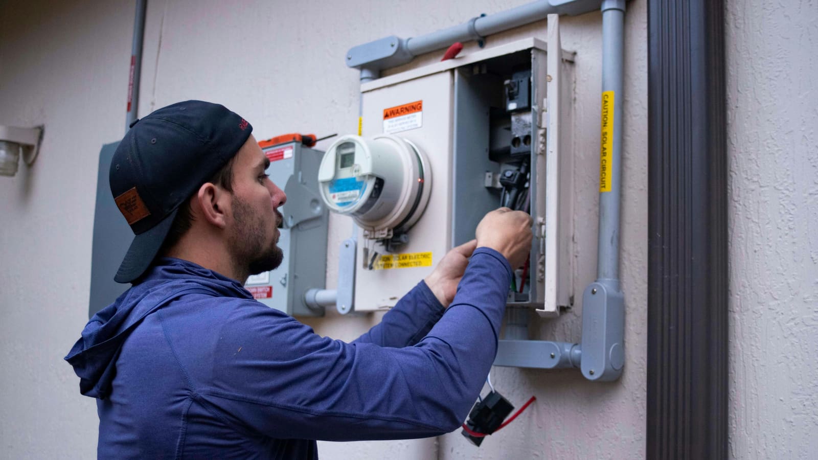 An electrician wiring a panel