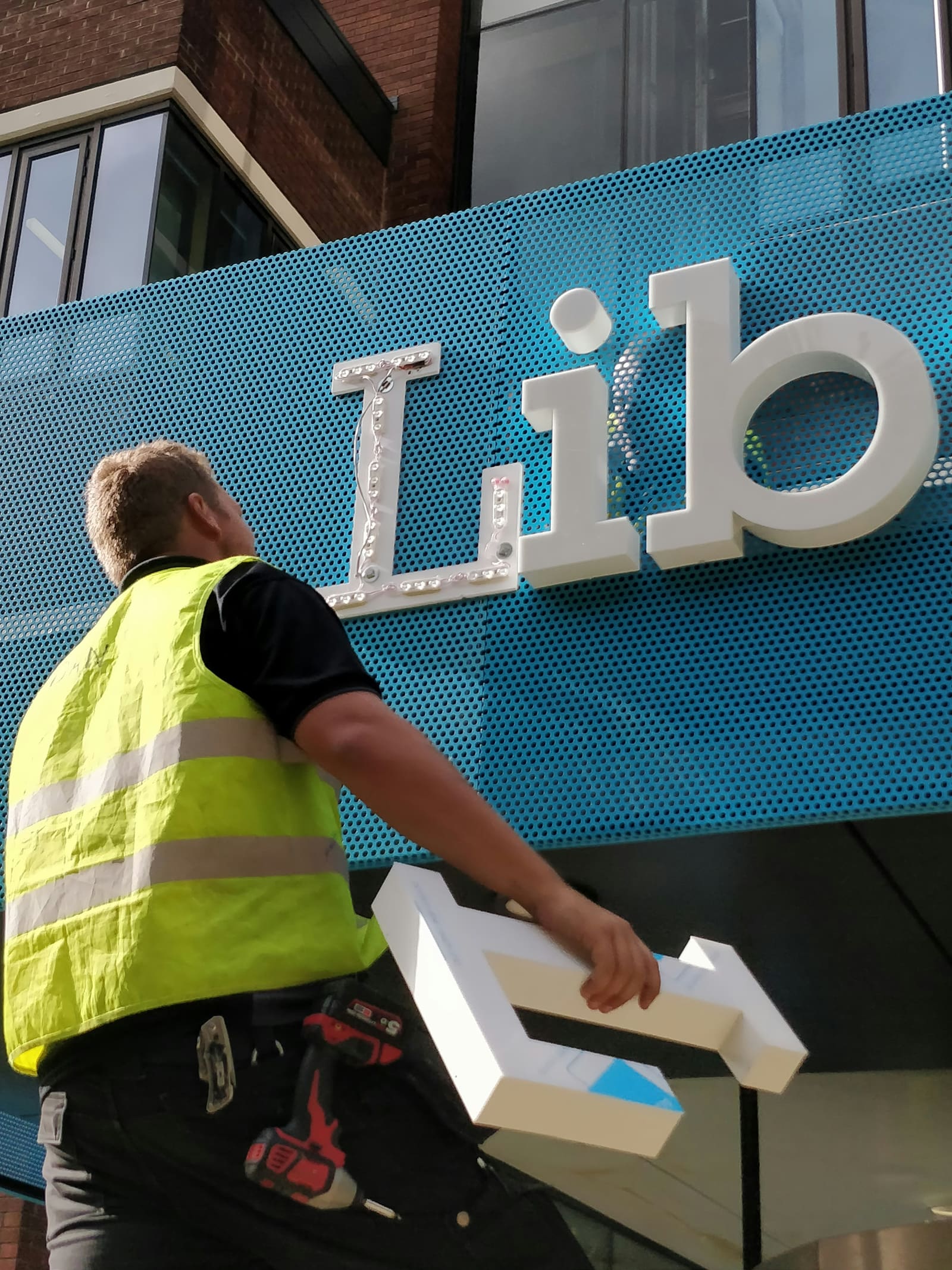 A worker installing a large sign